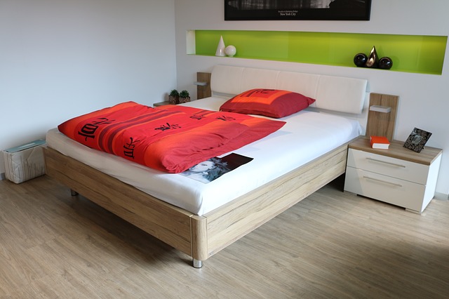 postel, červené povlečení, polička, stolky